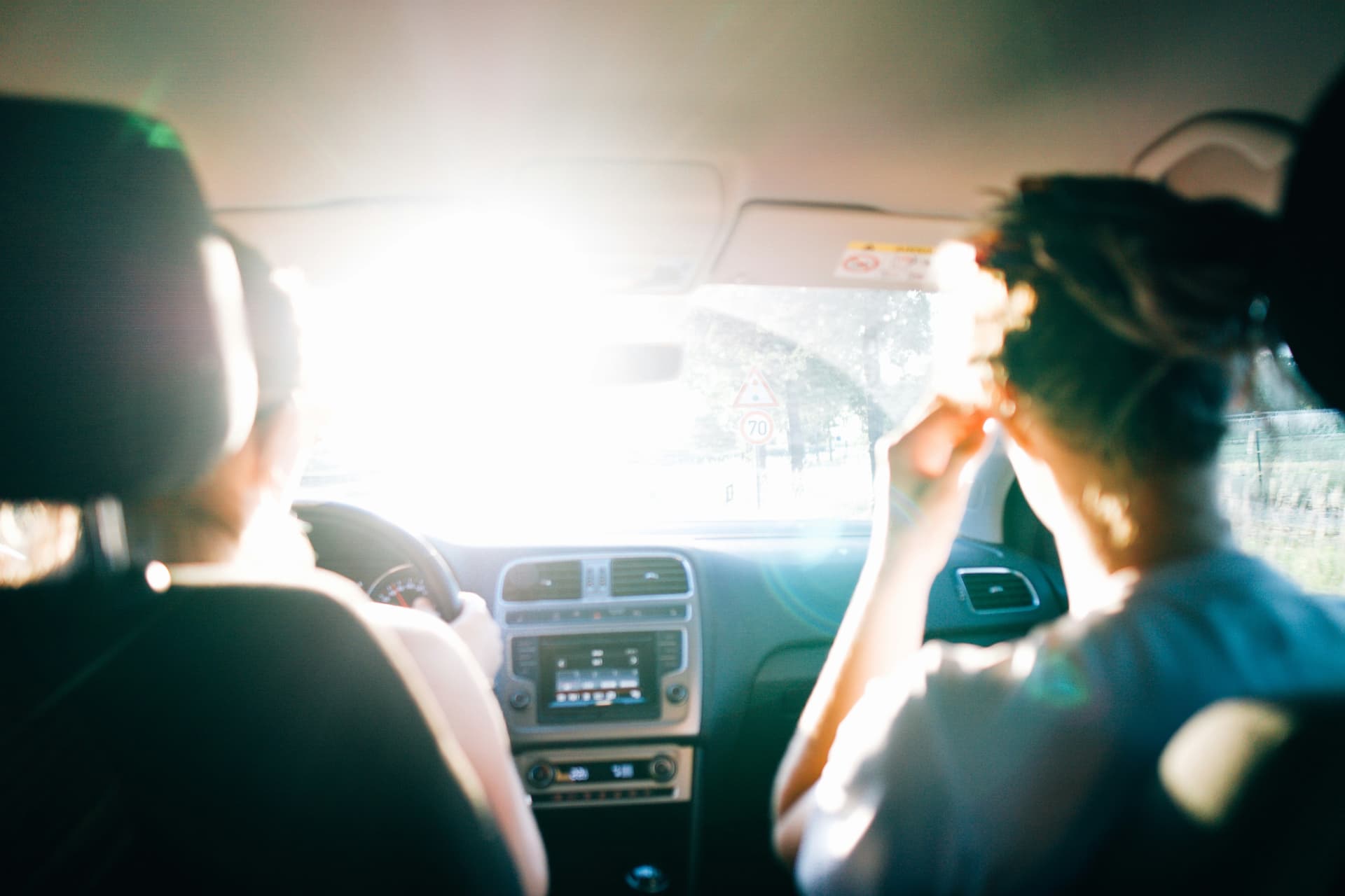 Pareja en coche viajando con luz de verano